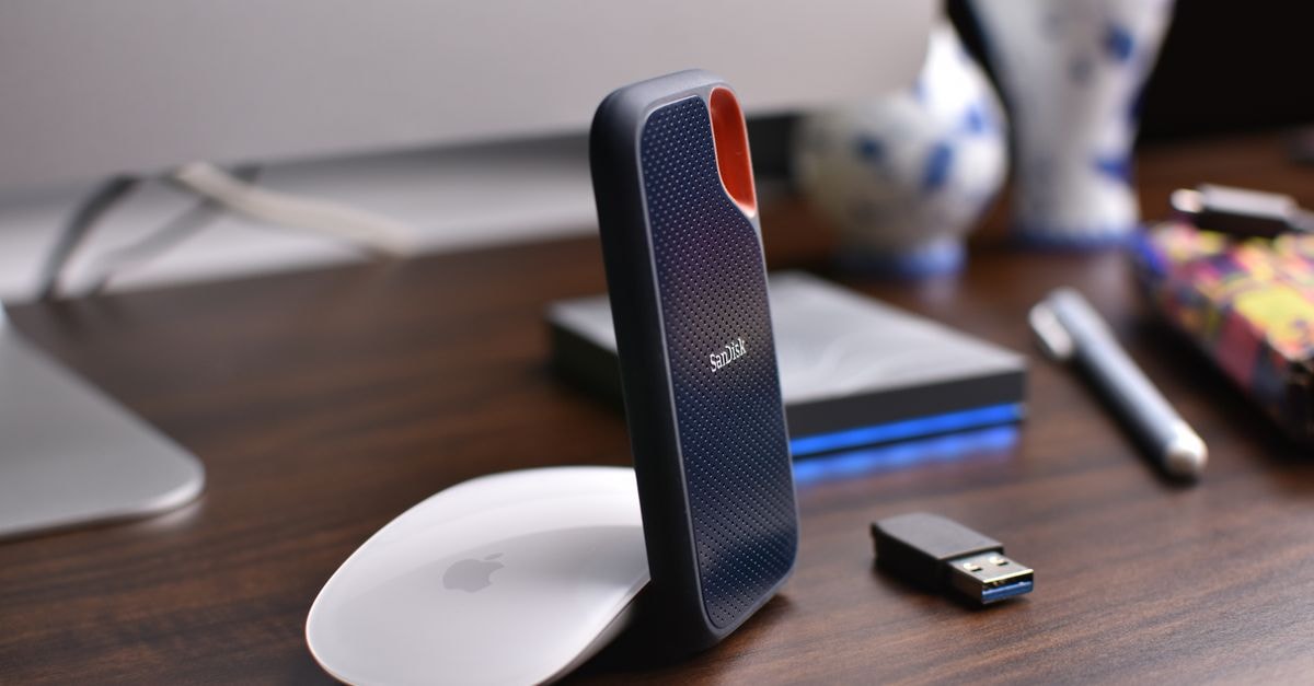 辦公桌近景，可見外接硬碟、USB 隨身碟與電腦滑鼠，適用於現代辦公環境。