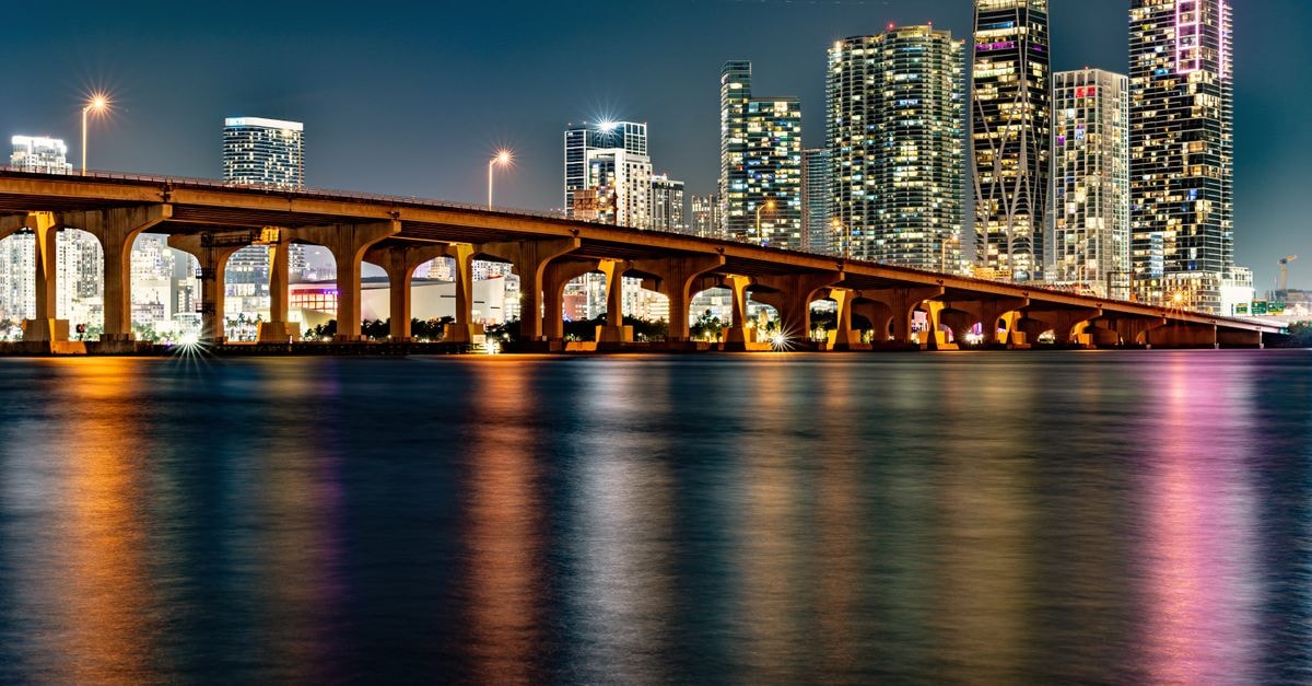 Hotel Real in Florida, Uruguay: A Quiet Base Near Estadio Campeones Olímpicos Illuminated Miami skyline with a bridge reflection at night.