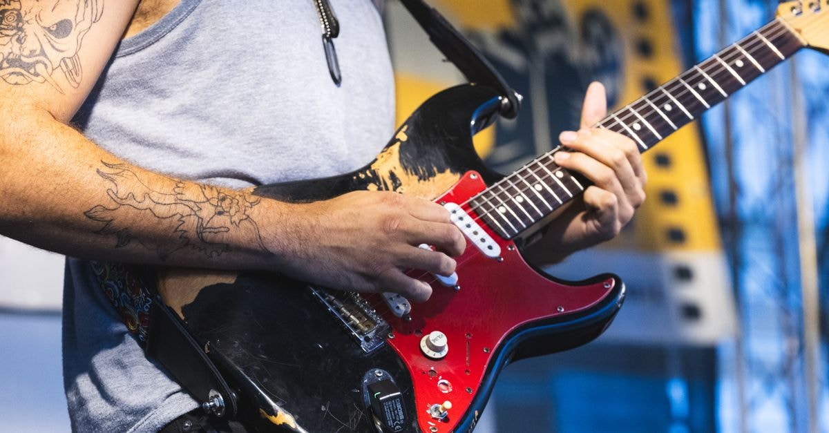 Kutna Hora Travel Guide: Planning Tips, Costs and Things to Do Guitarist with tattoos performing outdoors at Kutná Hora festival.