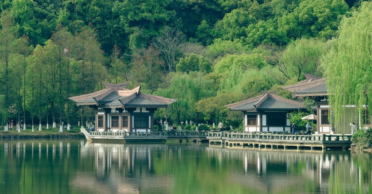 Xuancheng Travel Guide: Planning Tips, Costs and Things to Do Peaceful Japanese garden setting with traditional buildings and lush greenery reflecting on a calm lake.