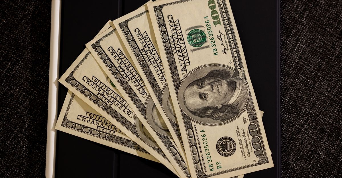 Adobe Sets Sept. 10 Release for Q3 FY2026 Earnings Spread of US dollar bills on black surface with stylus, symbolizing finance and technology.