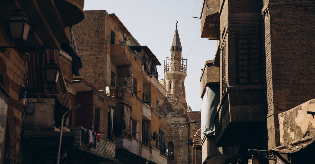 Narrow street in Cairo featuring historic Islamic architecture and urban life.