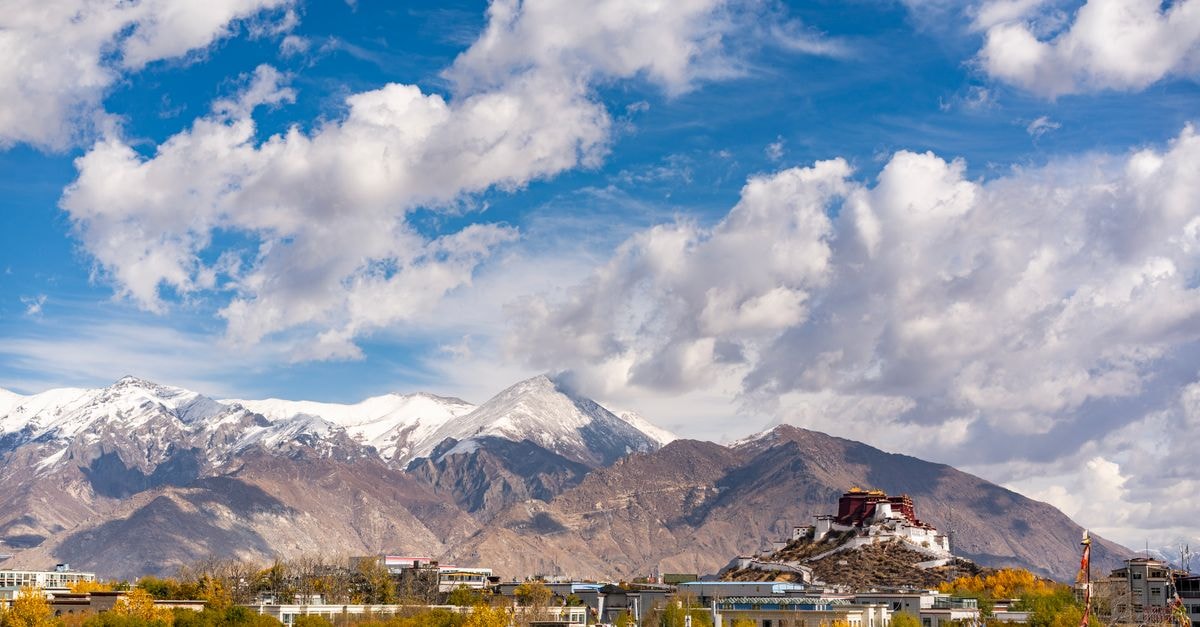 Tashi Choeta Tibetan Folk Hotel, Lhasa — A Stay on Beijing East Road Breathtaking view of Potala Palace amidst mountains and vibrant autumn landscape in Lhasa, Tibet.