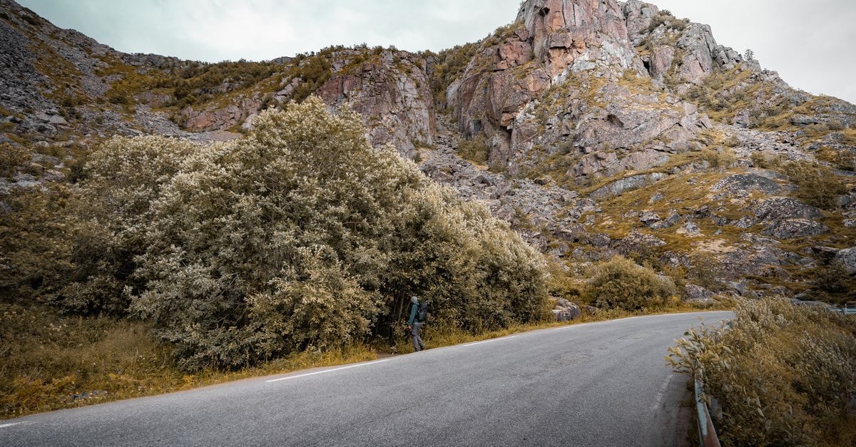Explore the serene landscape of Henningsvær with winding roads and majestic mountain views.
