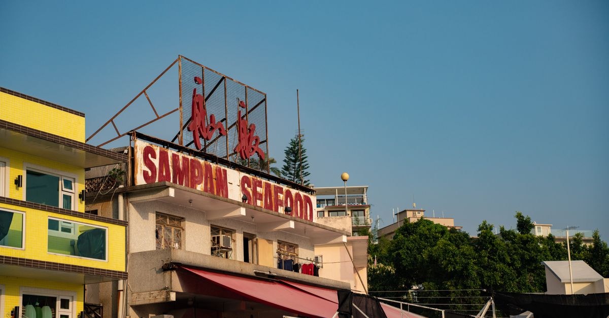 Shanwei Travel Guide: Coastal Calm and Old-Street Flavors Sampan Seafood restaurant signage on building facade in Hong Kong under clear blue sky.