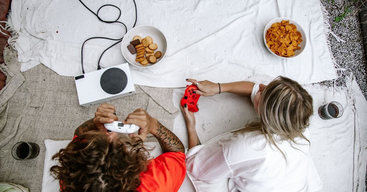 Digital Bros cancels Armed Fantasia, the Wild Arms successor planned for Nintendo platforms Overhead view of a couple playing video games on a console, surrounded by snacks.