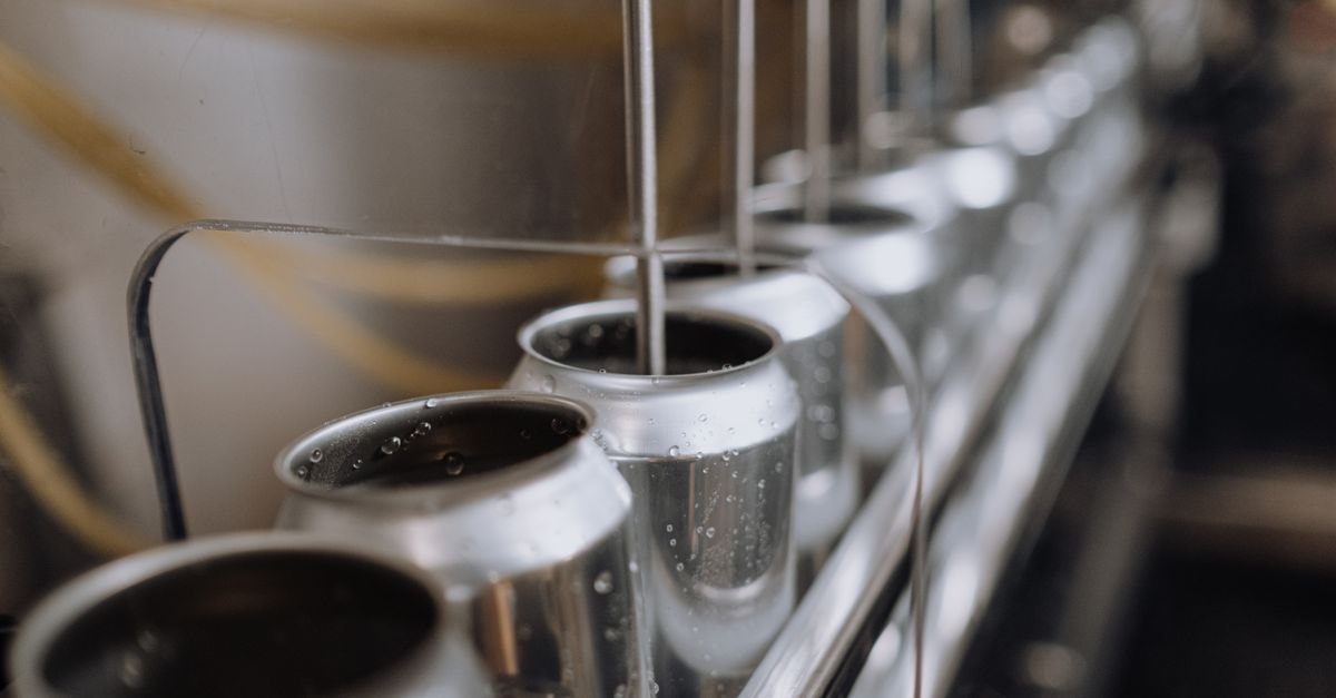 Linde plc: Industrial-Gases Franchise Priced Beyond What Mid-Cycle Cash Flow Can Pay For Detailed view of an industrial canning process with aluminum cans on an automatic assembly line.