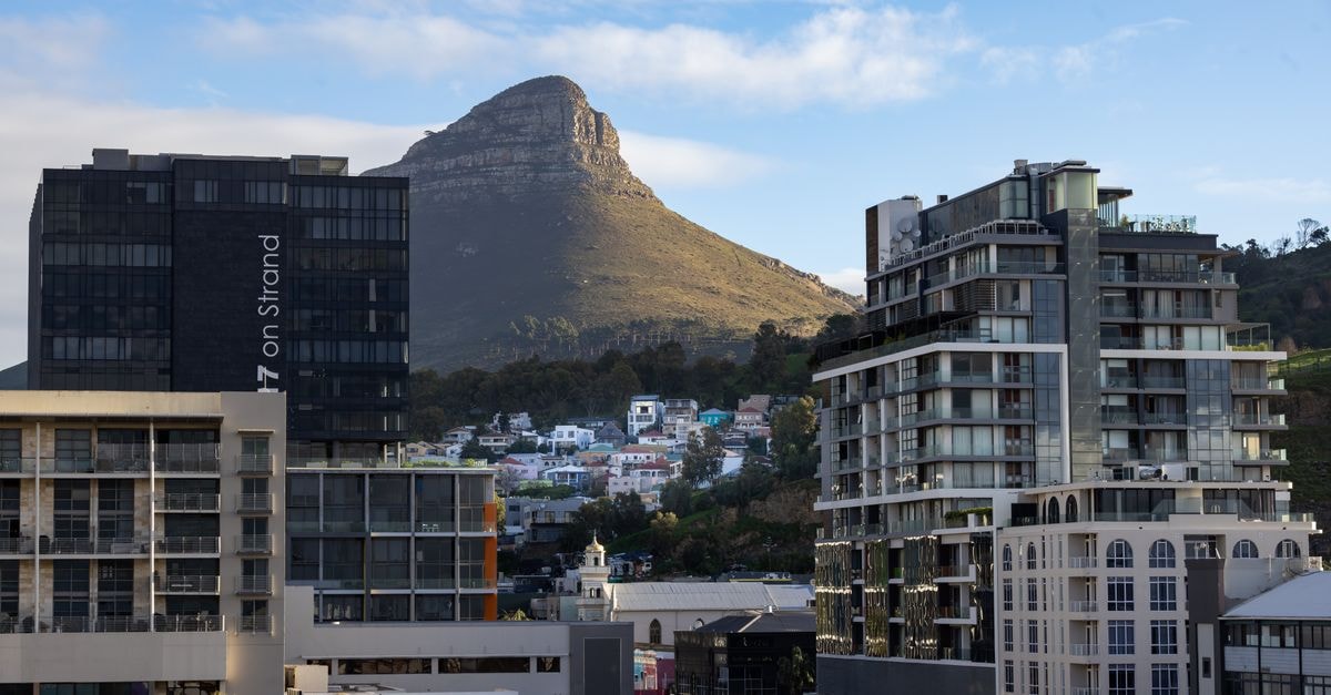 StayEasy Cape Town City Bowl, Cape Town — Bree & Strand Corner Base Scenic urban view of Cape Town with Lion's Head mountain in the background under a clear blue sky.