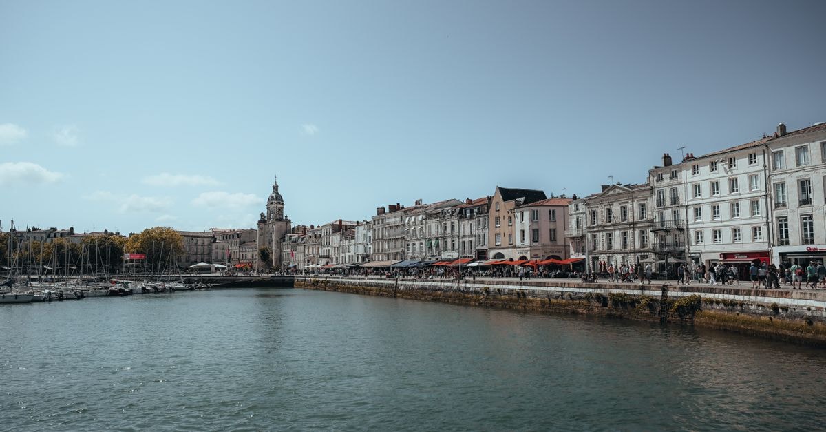 Kyriad Marne-La-Vallée Torcy in Torcy: A Practical Marne La Vallée Stay Scenic view of La Rochelle's waterfront with historic buildings by the sea under a clear sky.
