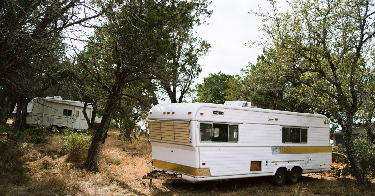 Sensuntepeque Travel Guide: Hill Country Calm in Cabañas Vintage camper trailers set amidst trees in a peaceful Texas forest scene.