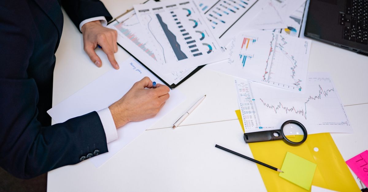 Close-up of a desk cluttered with financial charts, graphs, and reports, perfect for business and finance themes.