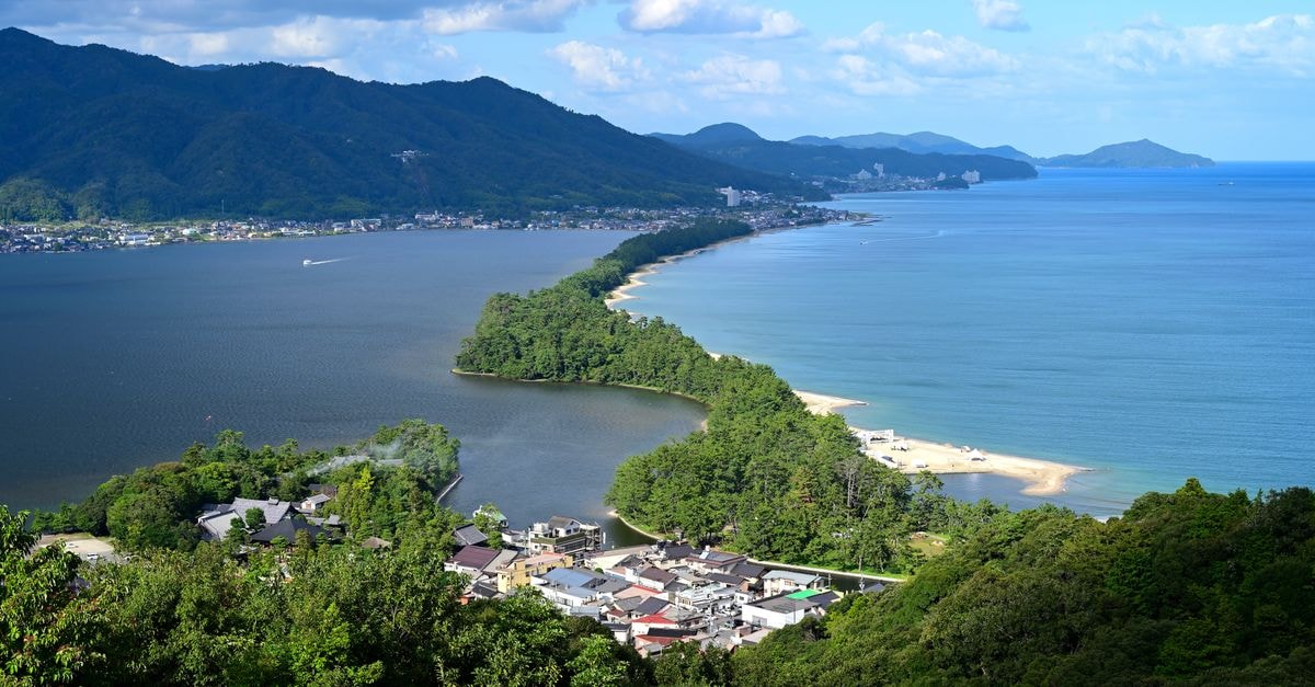 Tenkodogo Travel Guide: Planning Tips, Costs and Things to Do Stunning aerial view of Amanohashidate sandbar with vibrant greenery and blue waters in Japan.