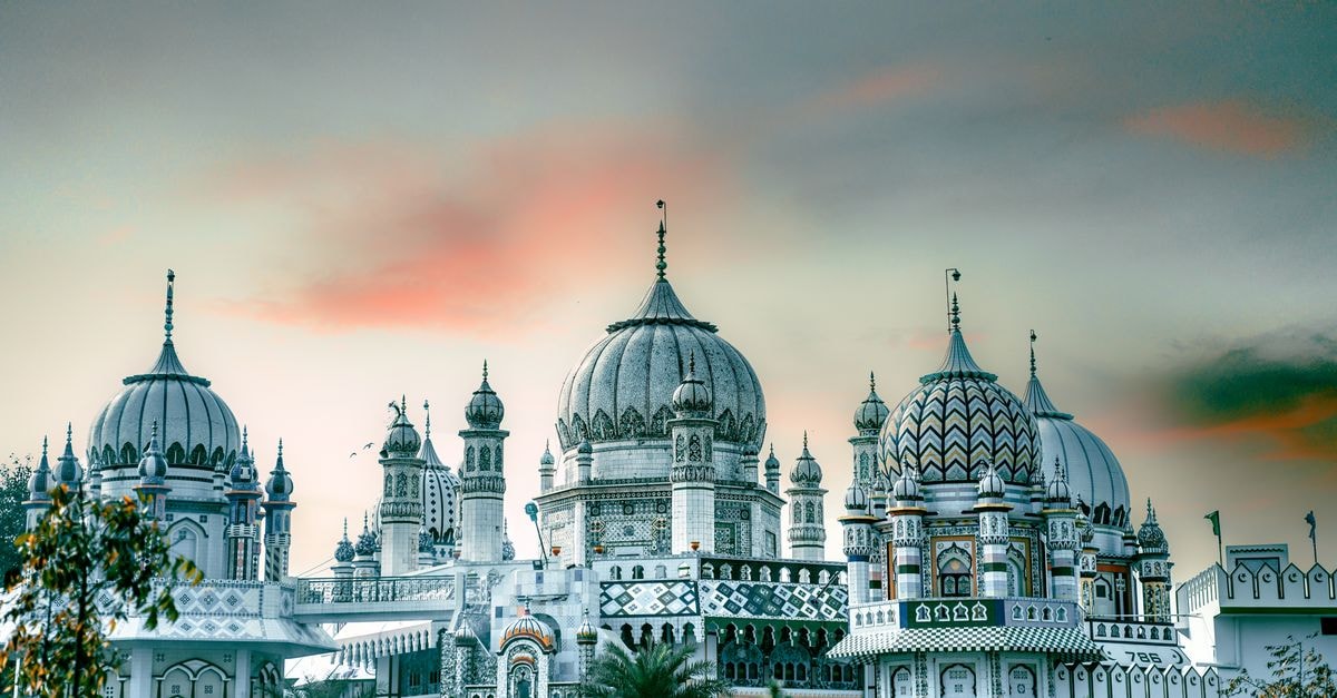 Agartala Travel Guide: Palaces, Temples and Slow City Days A stunning view of elaborate palace domes silhouetted against a vibrant sunrise sky.