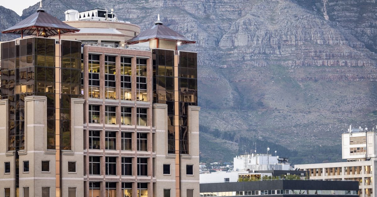 Cape Town Travel Guide: Planning Tips, Costs and Things to Do A modern office building with glass windows set against the backdrop of Table Mountain in Cape Town.