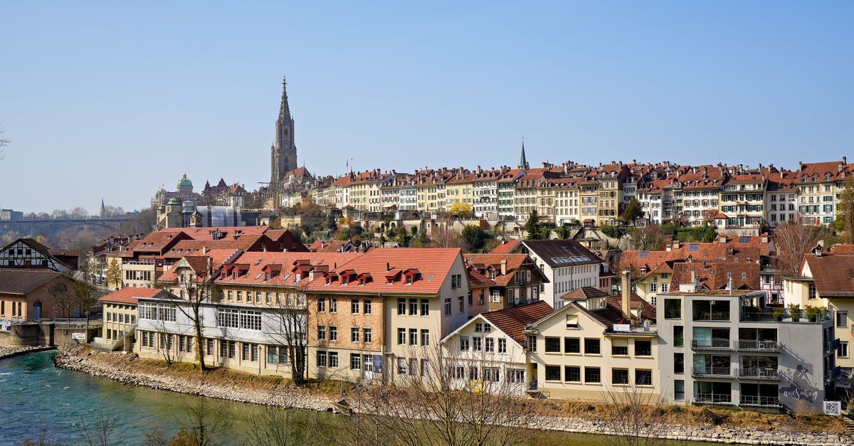Hotel Bern in Bern: Boutique Rooms and an Attika Bar View Explore Bern's iconic Old Town with its historic architecture and scenic river view under a clear blue sky.