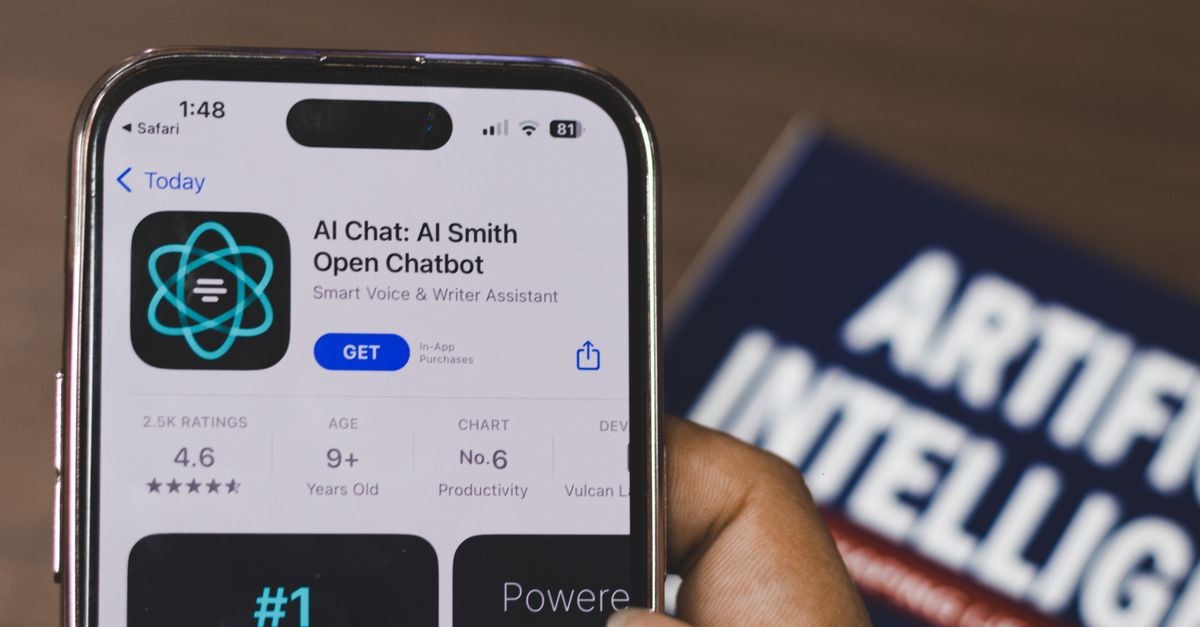 Amazon completes $50 billion OpenAI investment, locks in AWS as exclusive cloud provider Hand holding a smartphone with AI chatbot app, emphasizing artificial intelligence and technology.