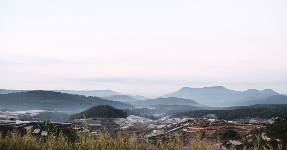 Ruyigi Travel Guide: Eastern Burundi's Quiet Highlands A peaceful mountain valley with misty hills at dawn, showcasing serene natural beauty.