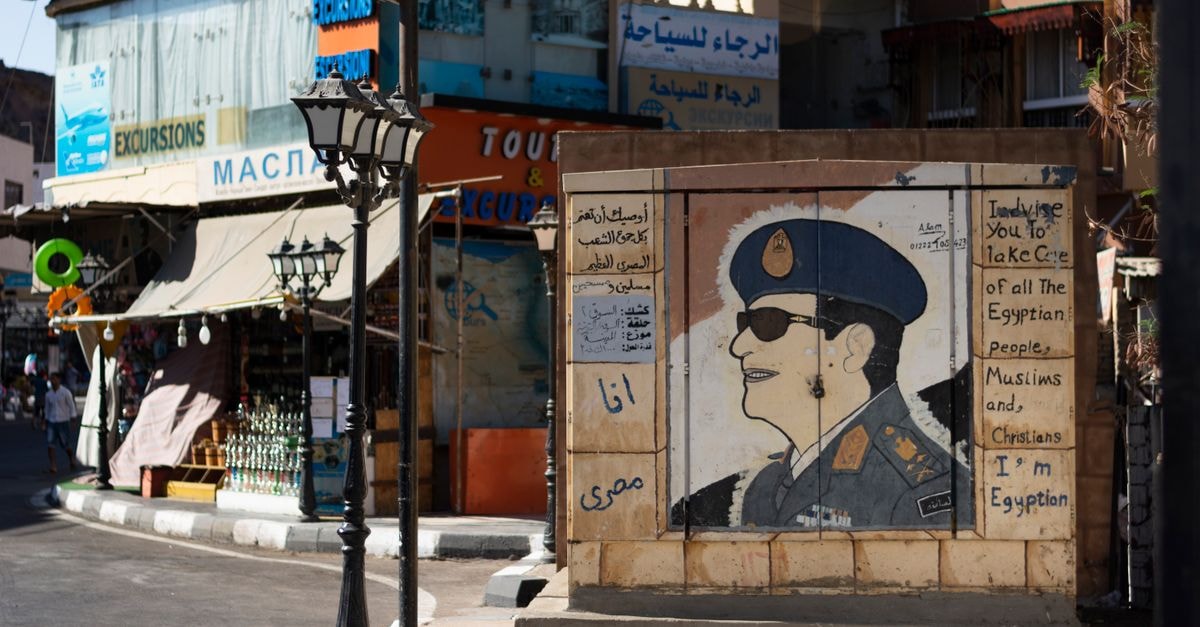 Intriguing street art depicting an Egyptian officer amid bustling shops.