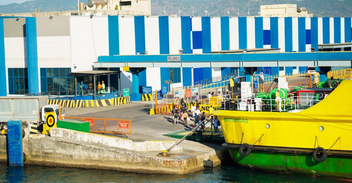 Saint-Marc, Haiti: a port city travel guide for slow travelers Sunny day view of Batangas Port with a docked yellow ferry and passengers disembarking.