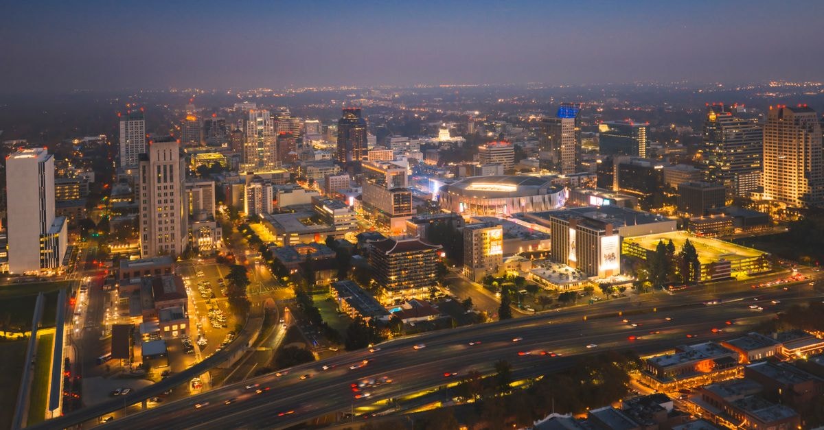Stunning aerial view of Sacramento's city skyline illuminated at night, showcasing bustling urban life.