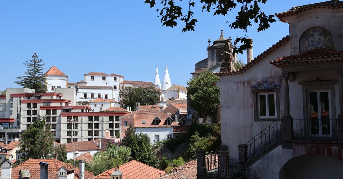 Beautiful view of Sintra's traditional architecture with a clear blue sky backdrop, showcasing historic charm and tiled rooftops.
