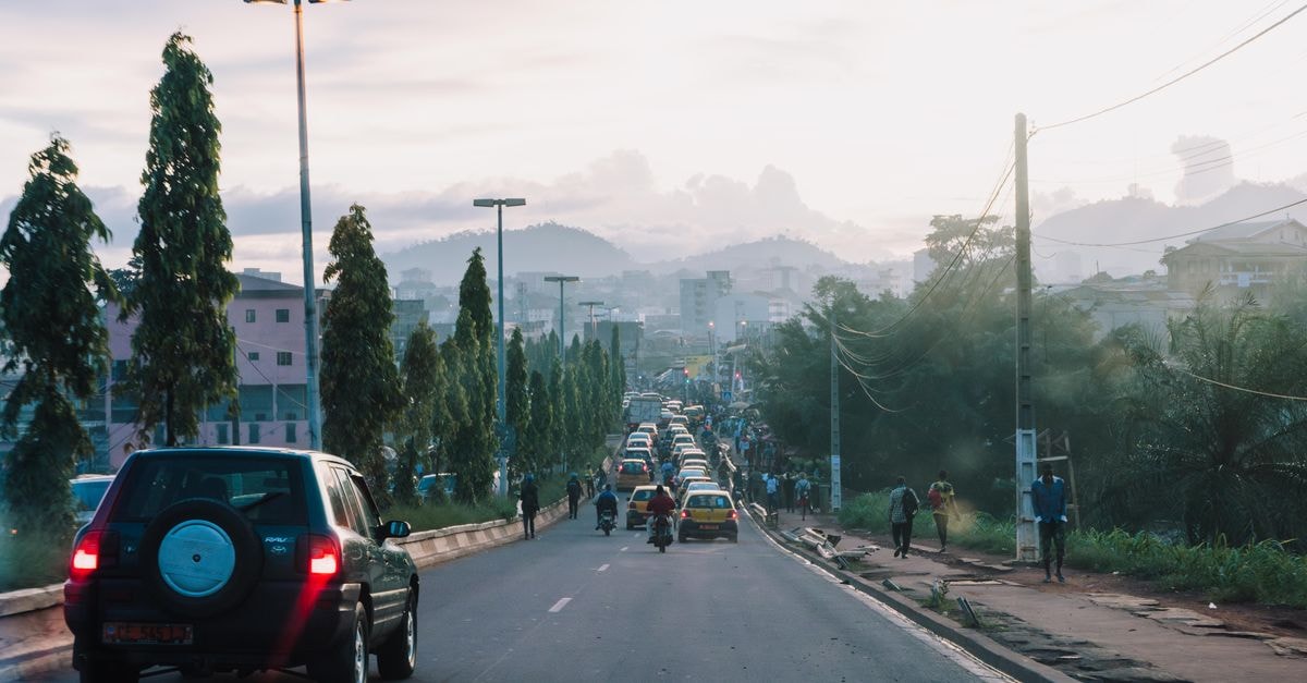 Bamenda Travel Guide: Highland Gateway to Northwest Cameroon View of a busy urban street during evening with vehicles and pedestrians.