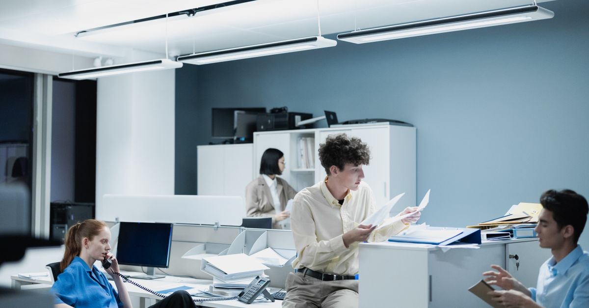 TEAM, INC.: Behind a Surging Share Price, Persistent Losses and a Stretched Balance Sheet Office team collaborating with documents in a modern workspace, focusing on teamwork and productivity.