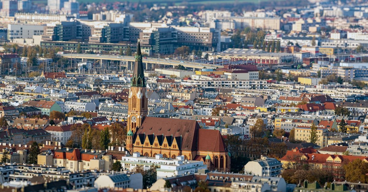 Hotel Maribor - Garden Rooms in Maribor: Royal-Size Beds in a Storybook Old Town Stunning aerial view of Vienna showcasing historic church spire amidst cityscape.