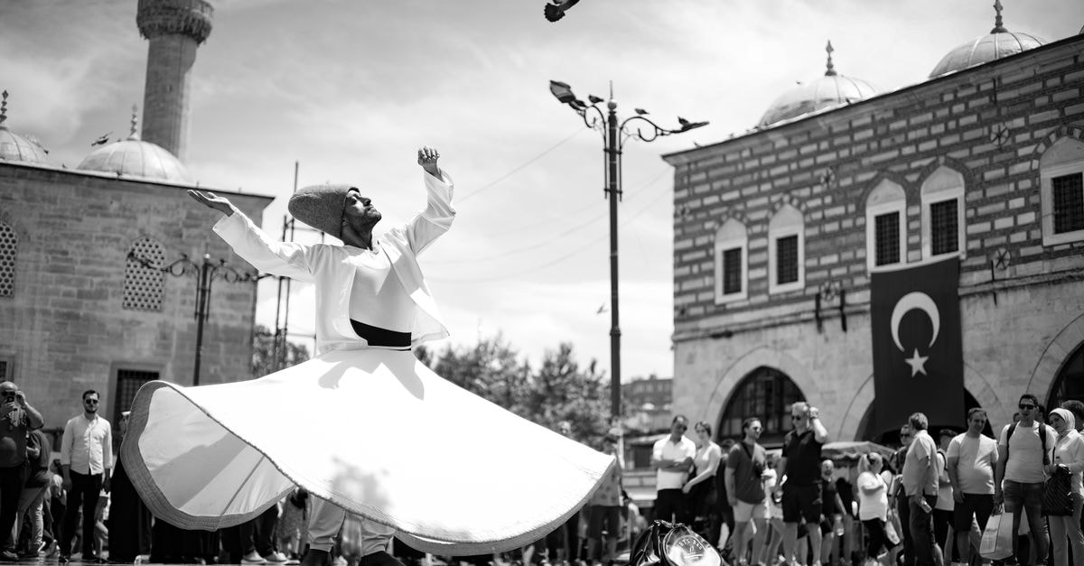 Konya Travel Guide: Whirling Dervishes, Old Stone, and Wheat A whirling dervish performing in front of a mosque with bystanders in Istanbul, Turkey.