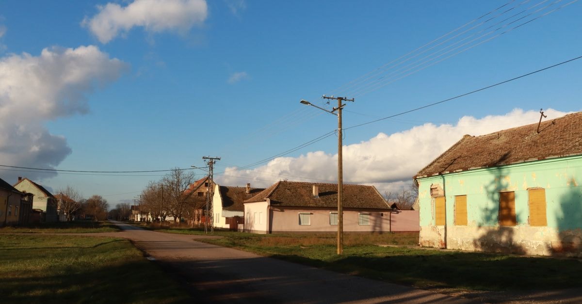 Szekszárd travel guide: tasting rooms, town squares and quiet Tolna roads Charming village street scene with rustic houses and clear blue skies.