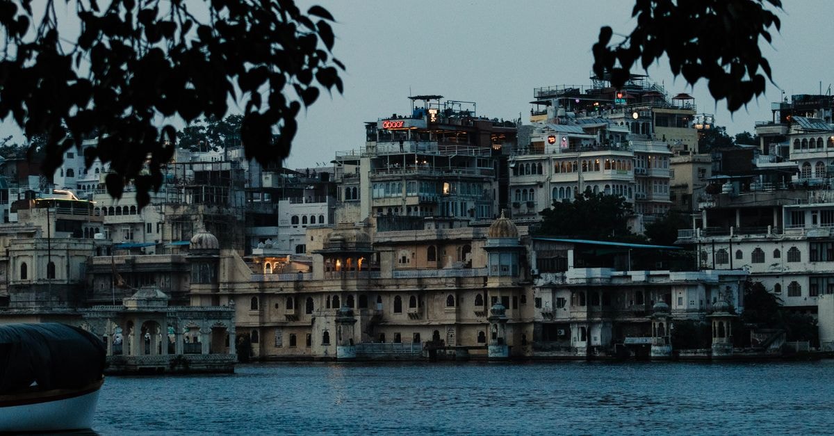 Sankalp, Udaipur: A South-Indian Stop on NH 8 Scenic view of Udaipur's City Palace and surrounding architecture seen from Lake Pichola at dusk.