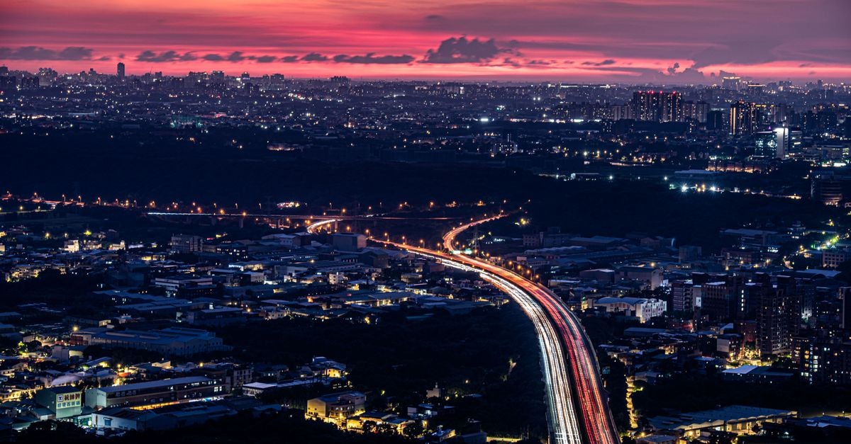 Hyatt Place New Taipei City Xinzhuang: A Smart Base for Modern and Historic Taipei Capture of Sanxia District's vibrant cityscape at twilight with colorful sky and light trails.