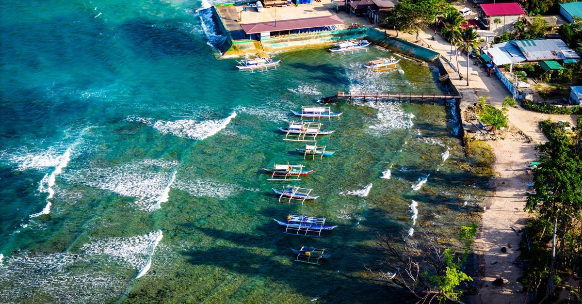 Stunning aerial photo of coastal Palawan with traditional boats and turquoise waters.