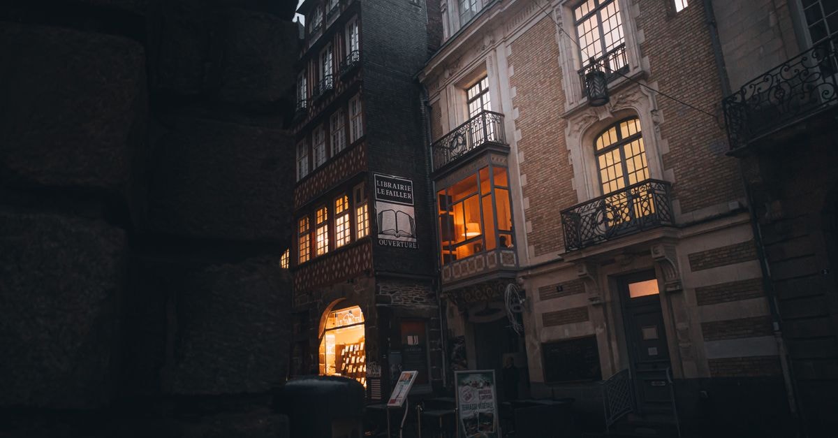 Rennes Travel Guide: Planning Tips, Costs and Things to Do Charming view of historic French street at twilight, showcasing elegant, illuminated architecture.