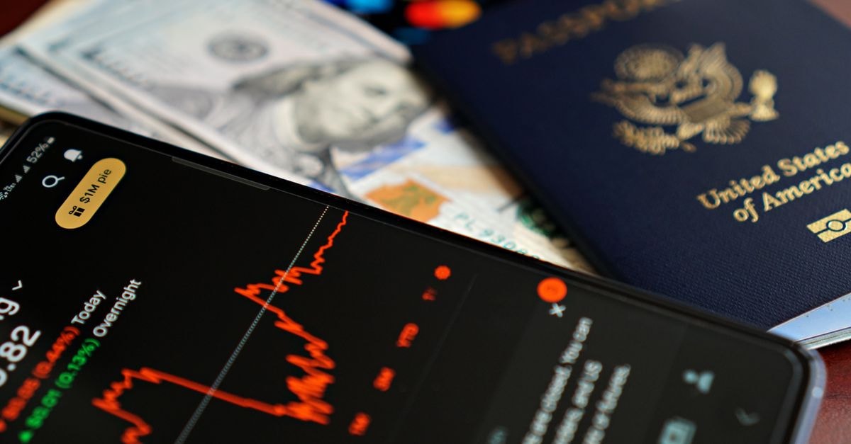 HSBC Hires JPMorgan Veteran Hannes Hofmann to Lead Global Family Office Push Close-up of smartphone with stock chart, cash, and US passport, symbolizing travel and finance.