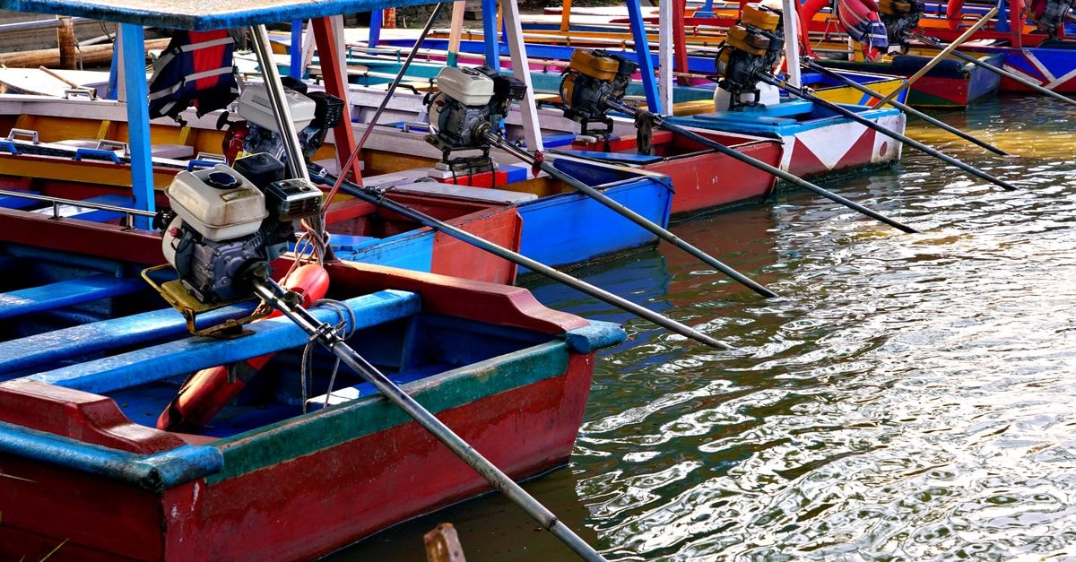 Arima Travel Guide: Getting Around Trinidad's Water Town A vibrant array of motorboats lined up along the riverside, highlighting colorful craftsmanship.