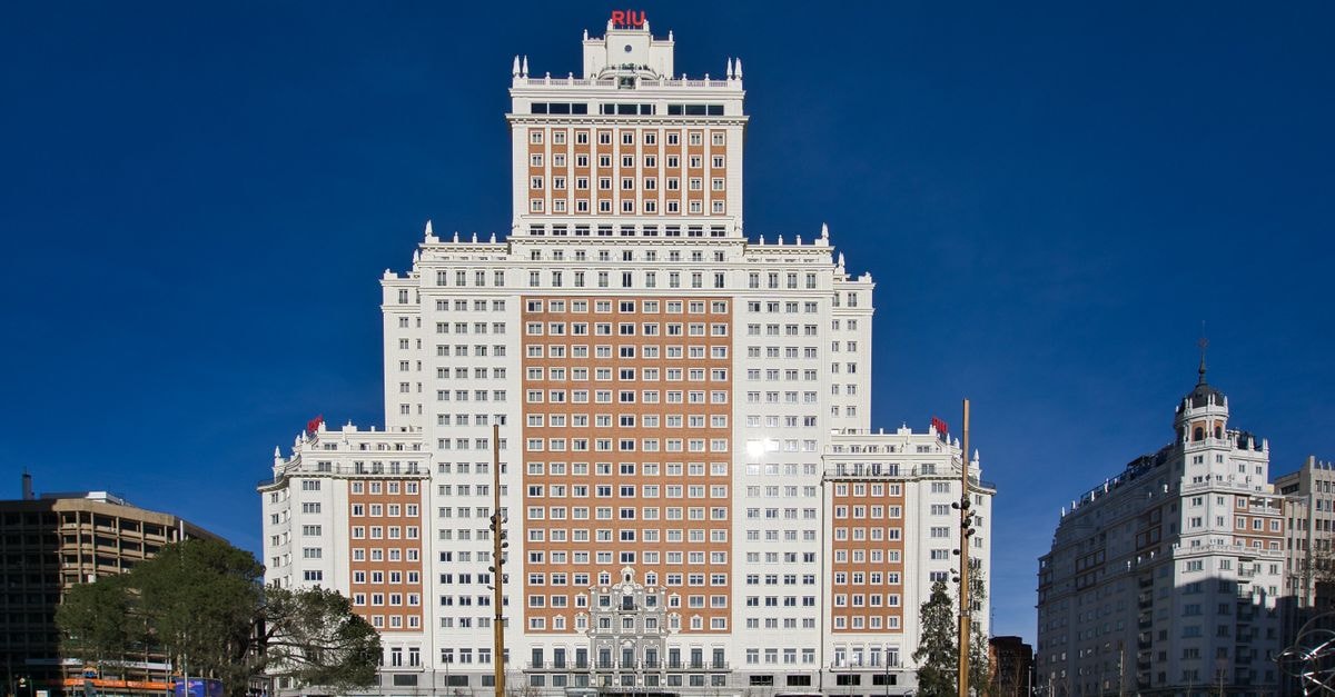 Hotel Mediodía, Madrid — A 1914 Neoclassical Landmark in the City Stunning view of Hotel Riu Plaza Espana with vibrant city life in Madrid, Spain.