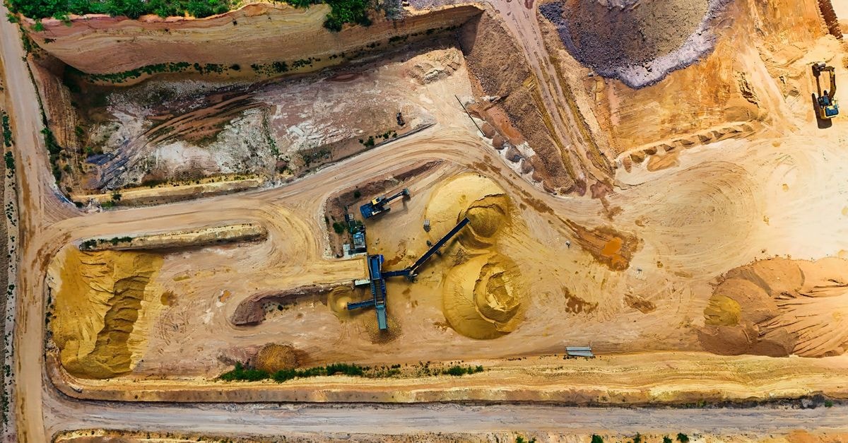 Gold extends rally on Treasury move and Fed minutes, with banks targeting above $5,000 by 2027 Aerial shot of a quarry with machinery extracting and processing materials.