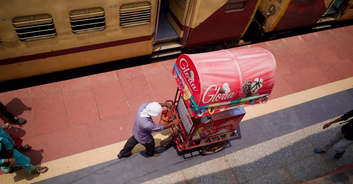 Siliguri travel guide: transport, heritage, and street food Ice cream vendor pushing a cart on a train platform in India.
