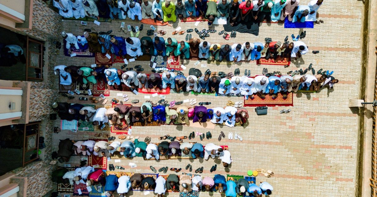 Hamdala Motel in Kaduna: Waff Road Heritage With a Civic Past Aerial view of people praying together outdoors in Kaduna, Nigeria.