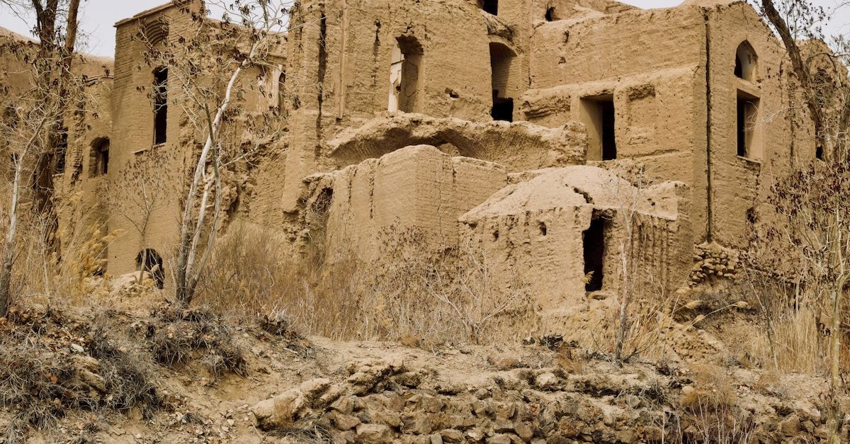 Wandering the Windcatchers: An Evergreen Yazd Travel Guide Captivating image of the historic abandoned mud-brick structures in Kharanaq, Yazd Province, Iran.