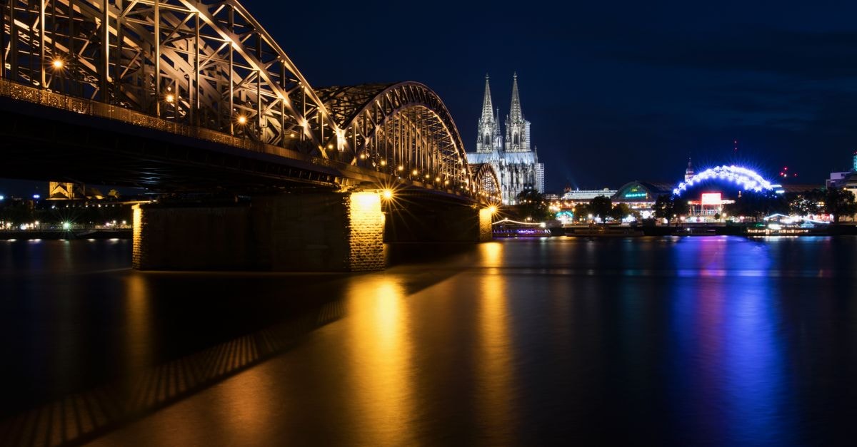 Stunning night shot of Cologne Cathedral and Hohenzollern Bridge over the Rhine River, Germany.