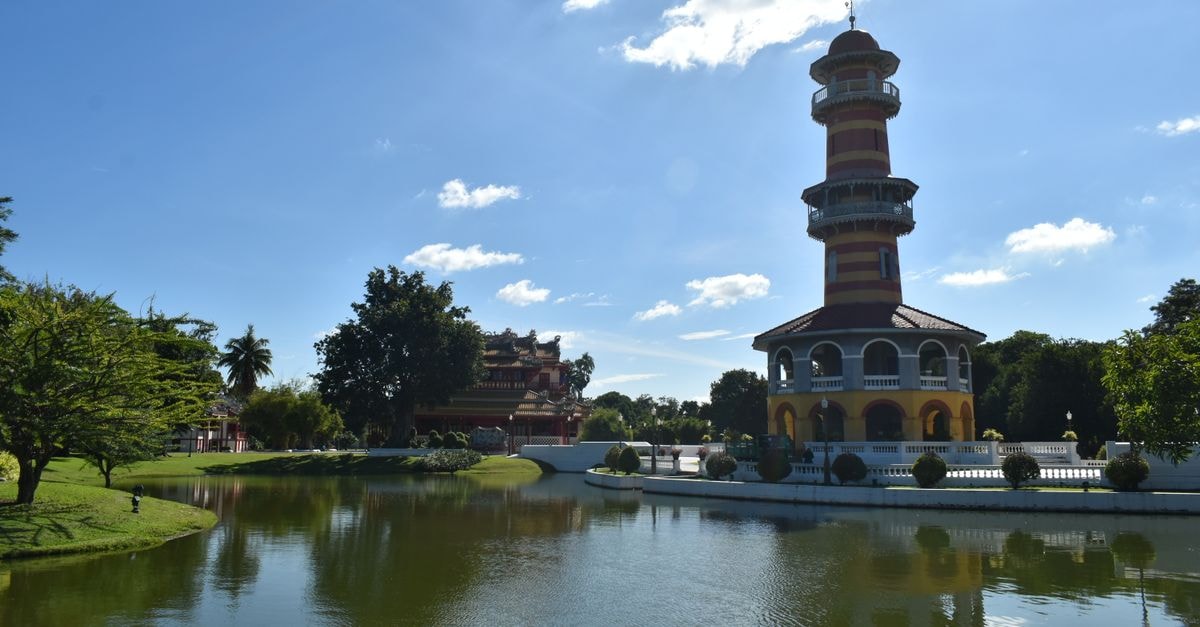 Beautiful view of a historical tower and pond in Phra Nakhon Si Ayutthaya, Thailand under a bright sunny sky.