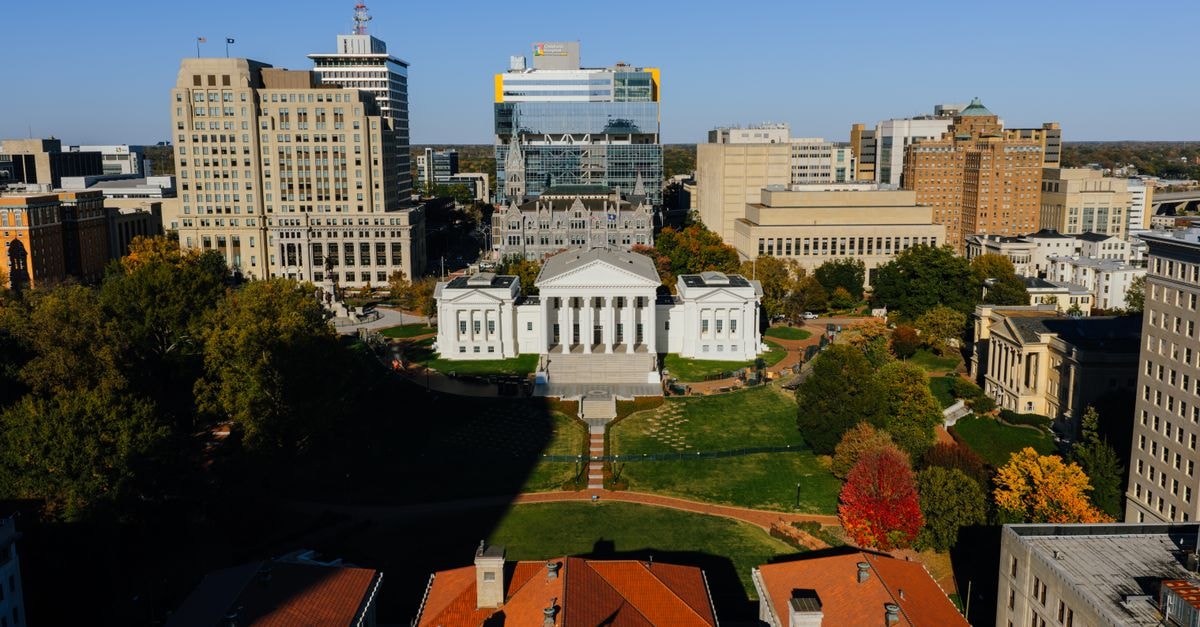 Aerial view of the Virginia State Capitol building surrounded by downtown Richmond, showcasing autumn colors.