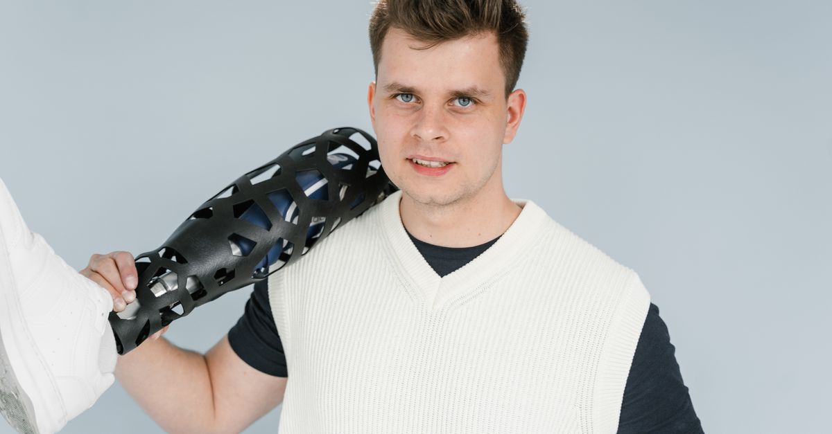 Meshy closes $400M Series B at $1.5B valuation as Kalogon and HeyGears expand 3D printing into medical and consumer markets A young adult holding a modern prosthetic leg during a studio photo shoot.