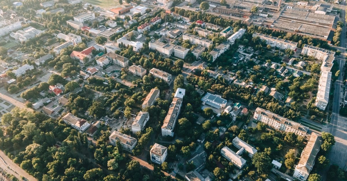 Aerial view of urban cityscape with residential buildings, roads, and greenery.