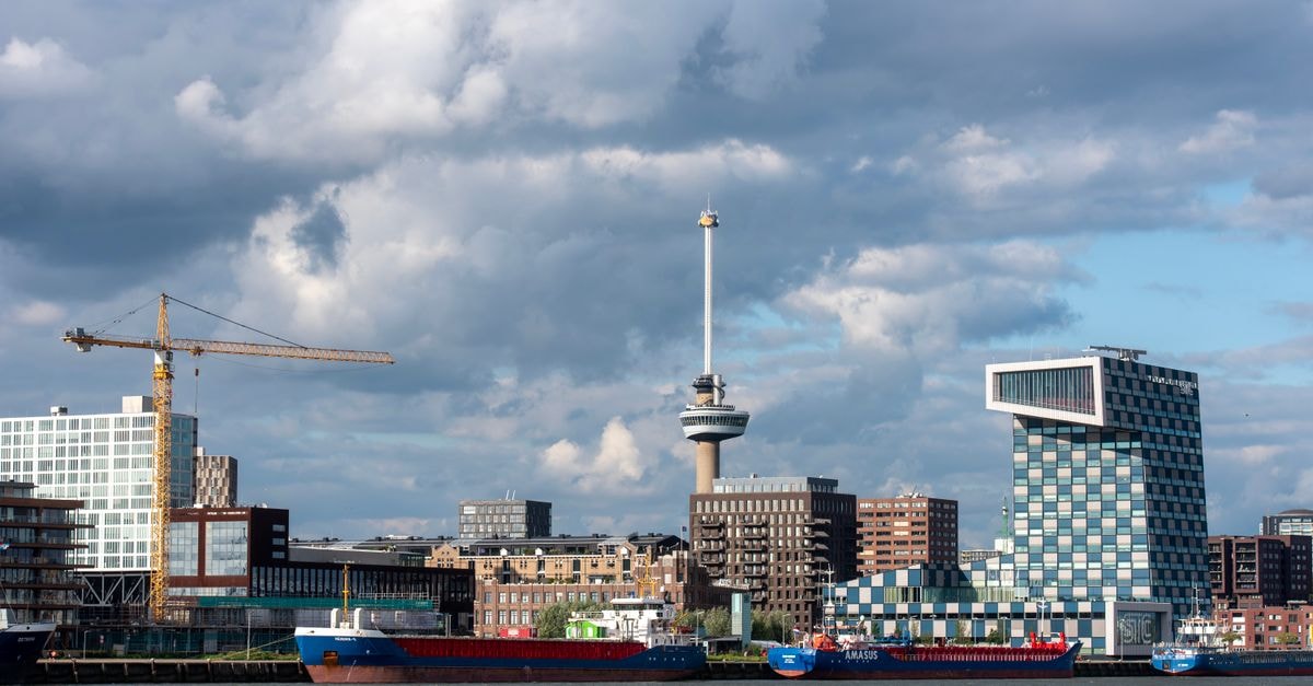 Rotterdam travel guide: architecture, energy, and flavor Rotterdam cityscape featuring the Euromast tower, cranes, and modern architecture along the river.