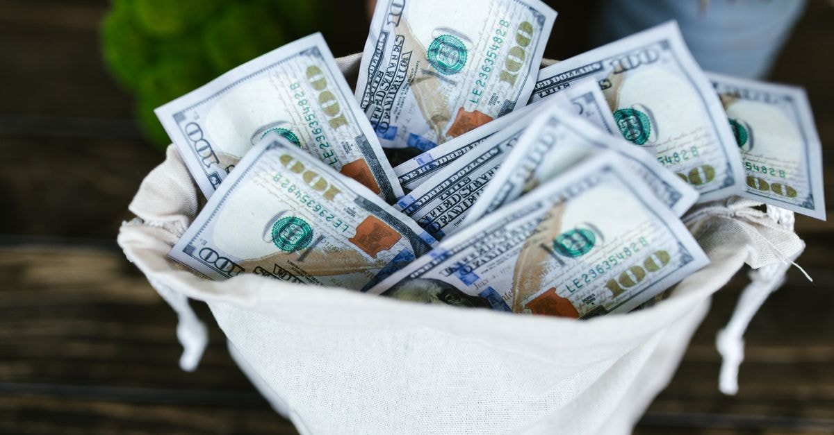 A top view of a sack brimming with US 100 dollar bills, symbolizing wealth and prosperity.
