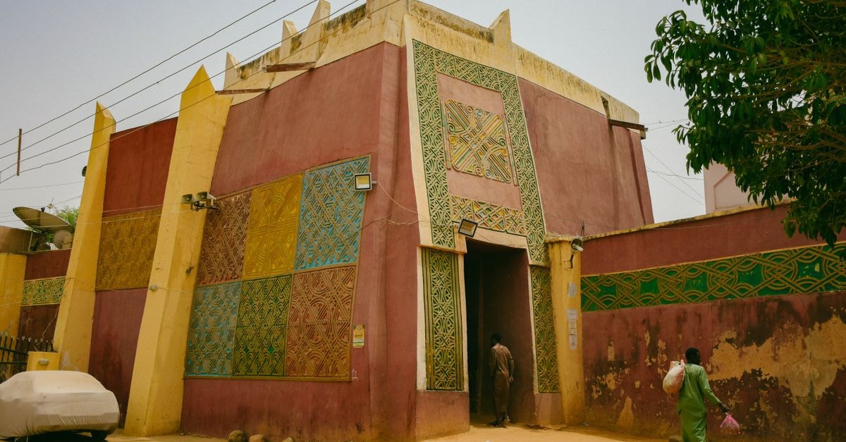 Sikasso Travel Guide: A Lush Corner of Mali Worth Slowing Down For Colorful building with intricate patterns in an urban Nigerian setting, showcasing unique architecture and street life.