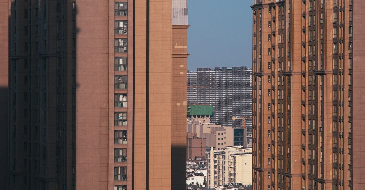 Story Time Hotel in Jinzhong: A Theme Apartment Near the University Town A cityscape view featuring skyscrapers and residential blocks with sunny sky.